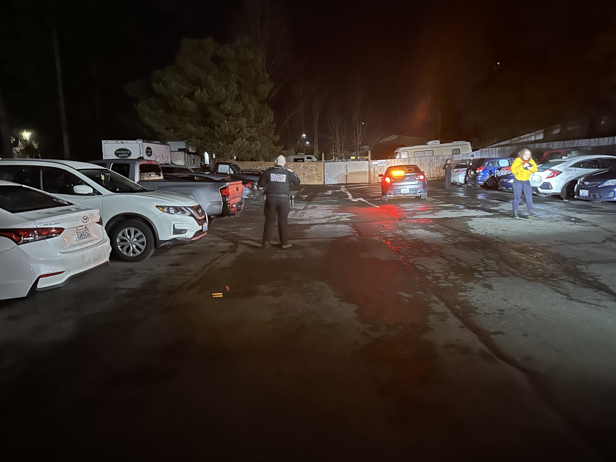 Falcon officer viewed from behind in a property parking area at night