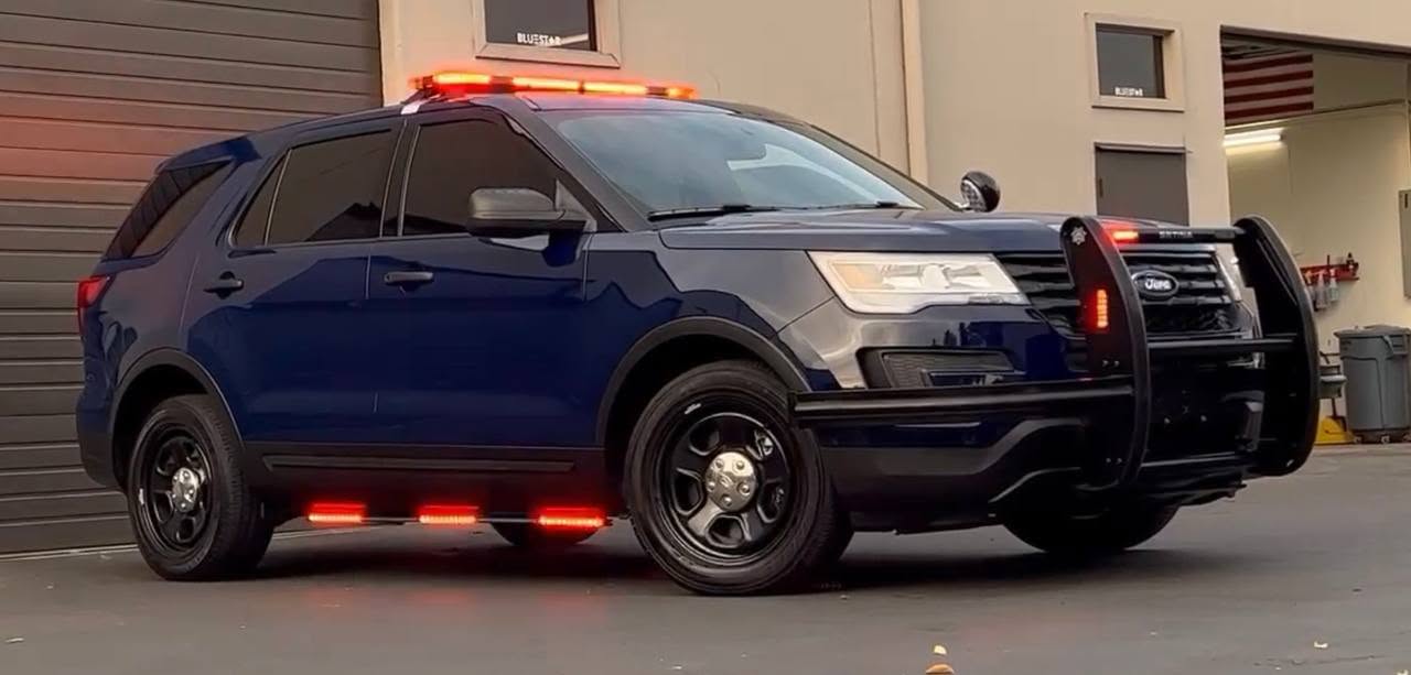 Blue Falcon patrol SUV with illuminated lights outside a garage