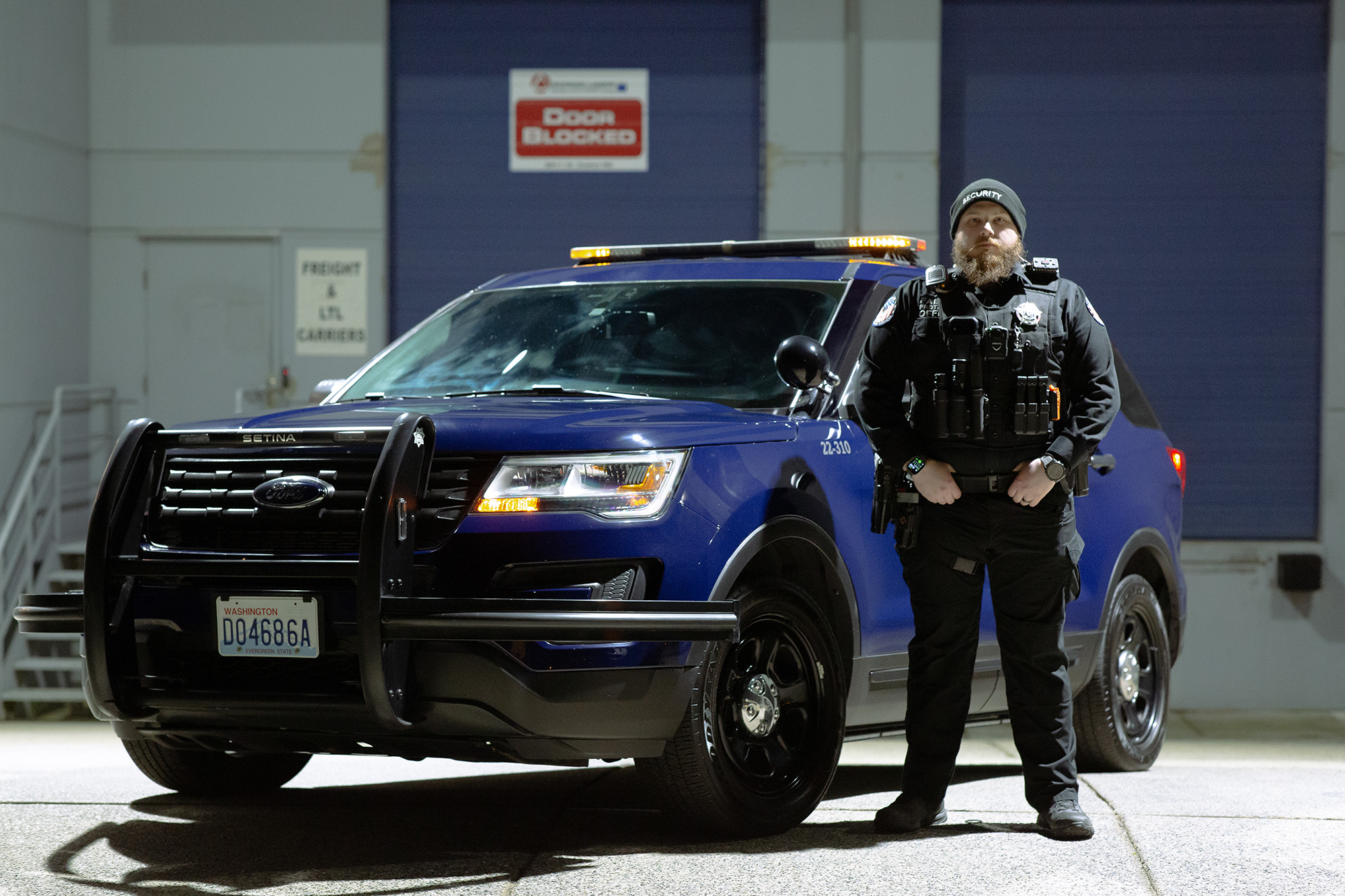 Patrick Leighton beside a blue Falcon patrol utility vehicle