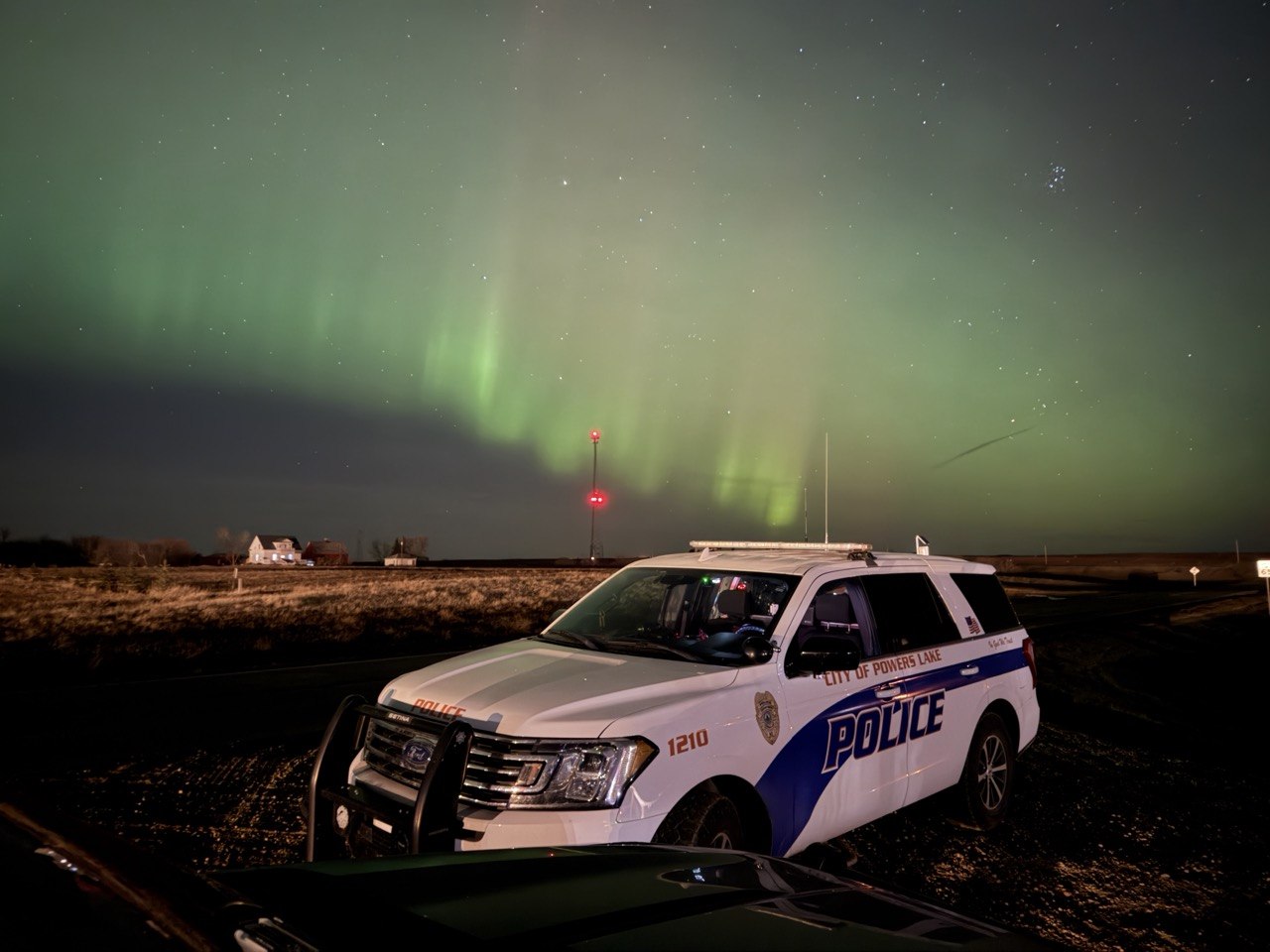 Powers Lake Police Department SUV beneath the northern lights